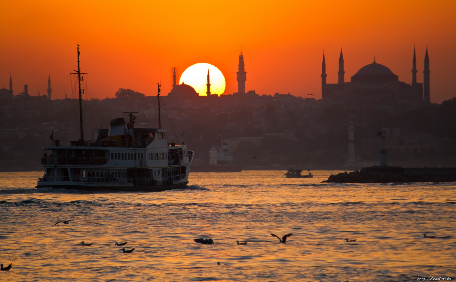 Ferry at sunset with warm sky and water reflections